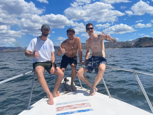Maxime with two other people on the Evasion Diving boat, with the Catalinas island in the background