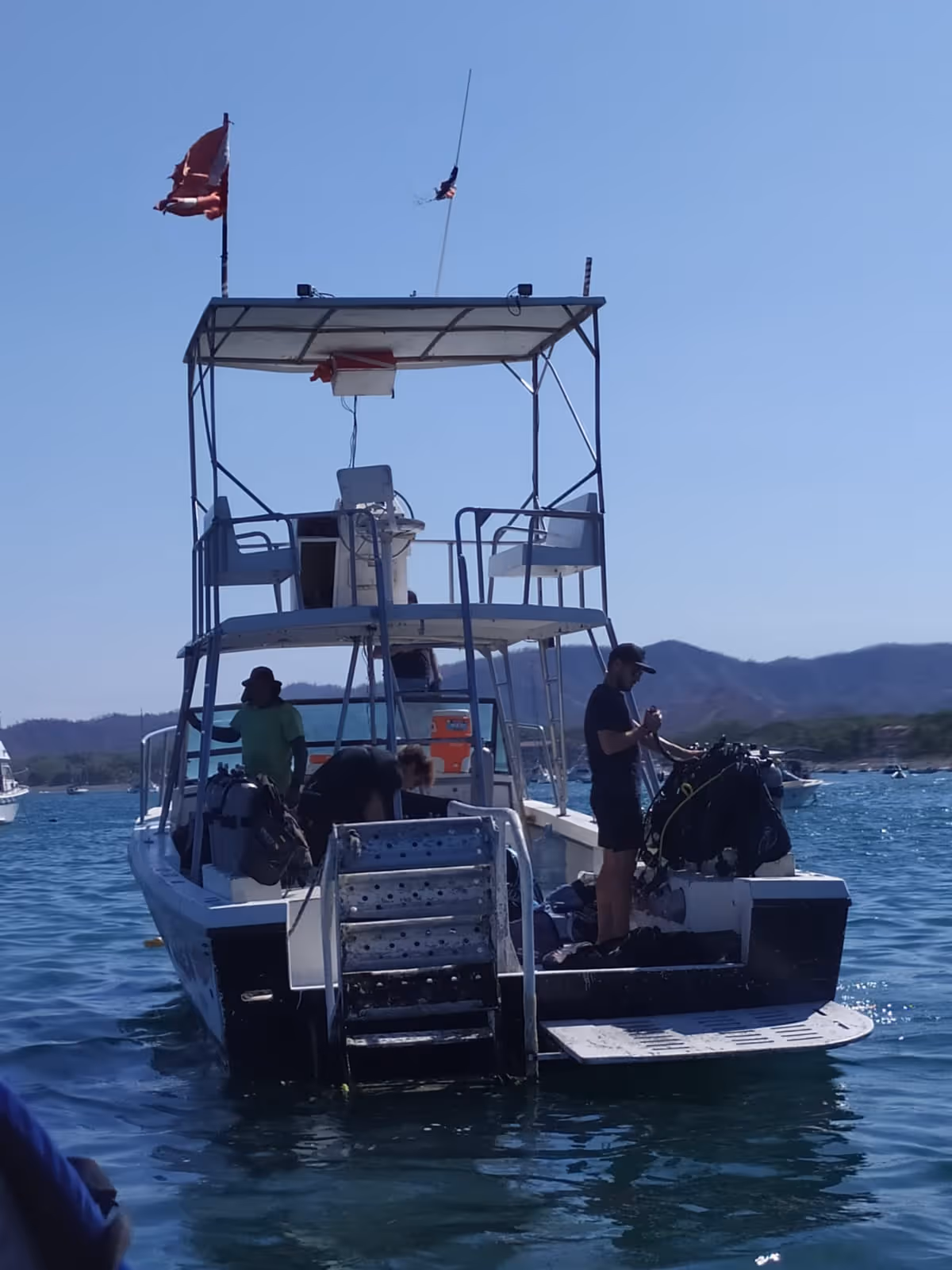 Buzos ascendiendo con parada de seguridad cerca del barco de buceo